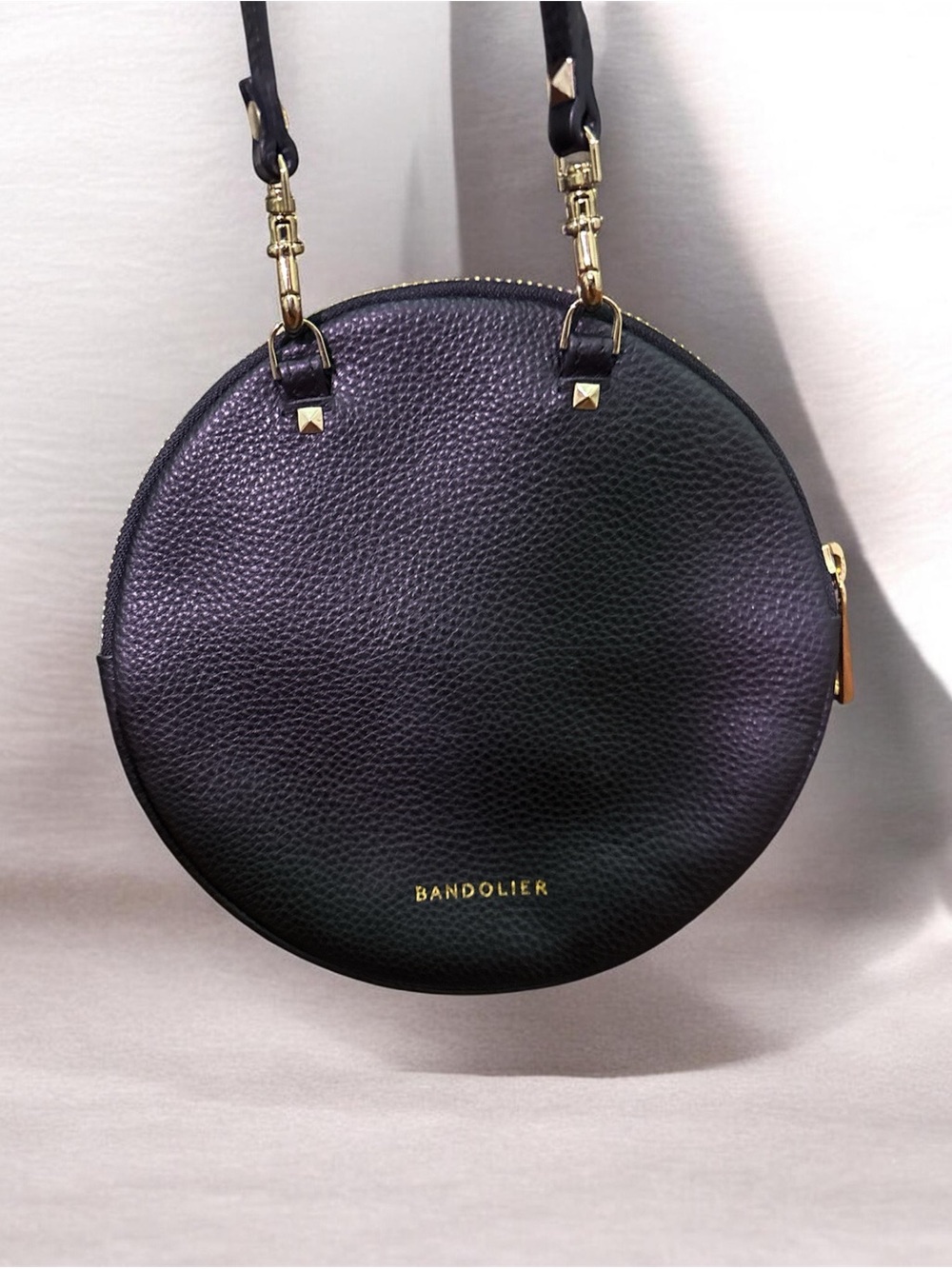 Bandolier Round Crossbody Bag with Sarah Studded Strap. Black pebbled leather